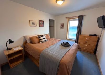 A main floor ocean view bedroom located in boutique Iqaluit B&B with private en-suite washroom and cozy queen bed