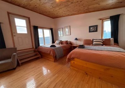 Large windows and private balcony in Room 1 at Stay by the Sea offers two queen beds and a panoramic view of Frobisher Bay and perfect spot to watch the Northern Lights